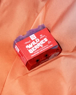 Wild Berries handmade soap by Hank Brussels with red packaging, placed on soft orange fabric.