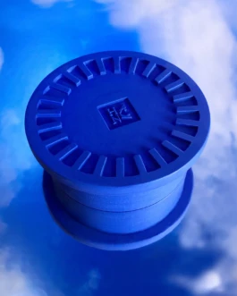 Blue Poly candle lid designed and handcrafted by Hank Brussels, photographed against a reflective sky backdrop.