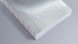 Close-up of L’Odyssée du Style book cover by Astrid Eckelmans, with mirror chrome finish, embossed typography, and red thread exposed binding. Editorial design and art direction by Hank Studio.